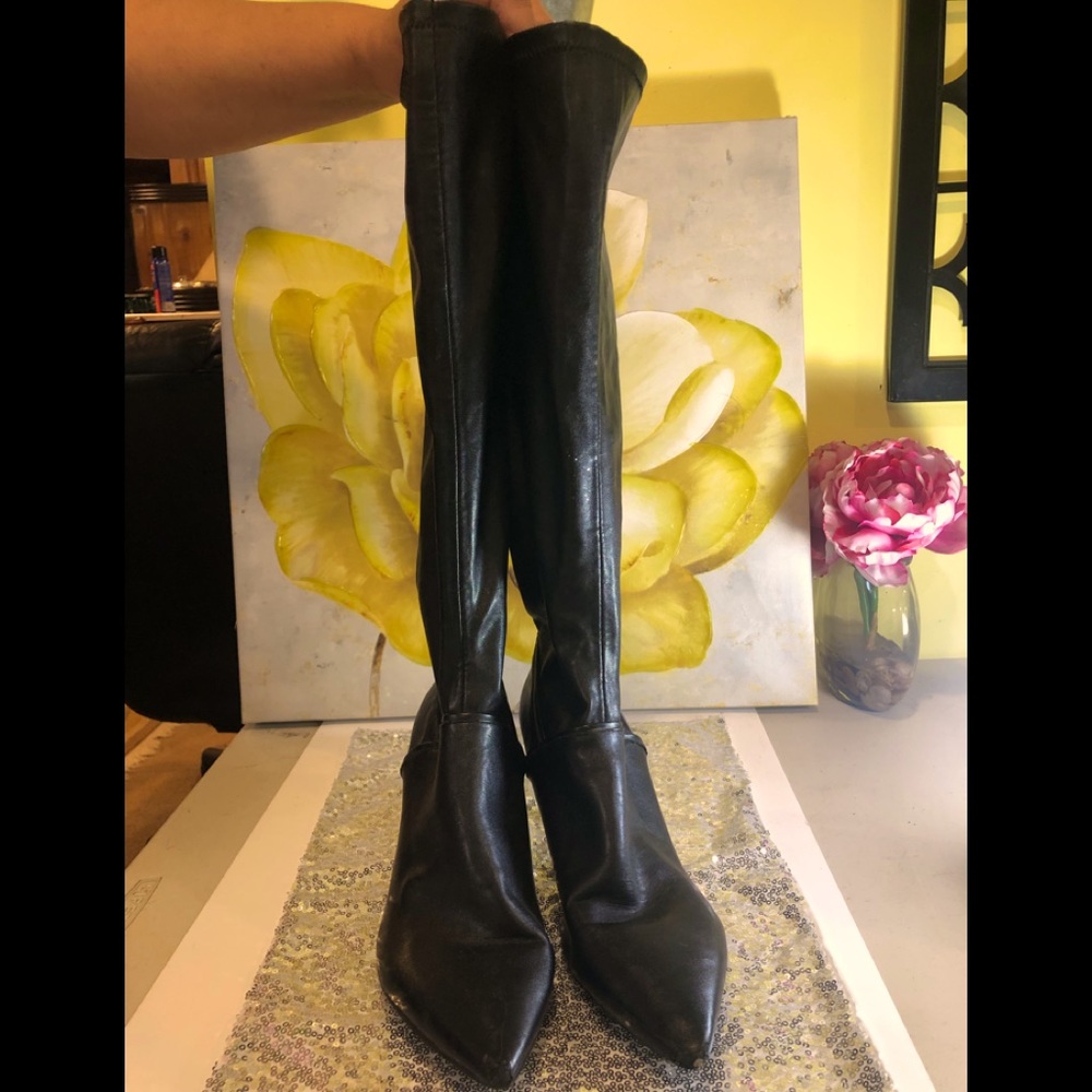 Knee high low heel black boots.